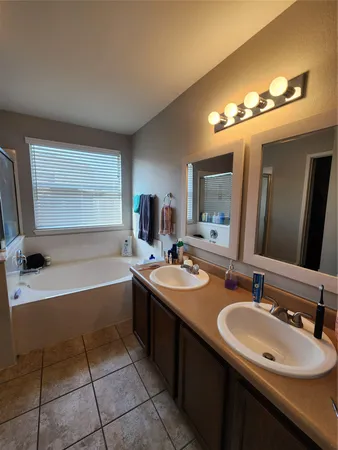 a bathroom with a sink double vanity granite and a bathtub