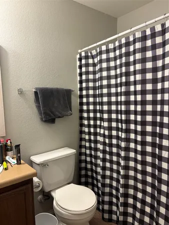 a bathroom with a toilet and a shower curtain