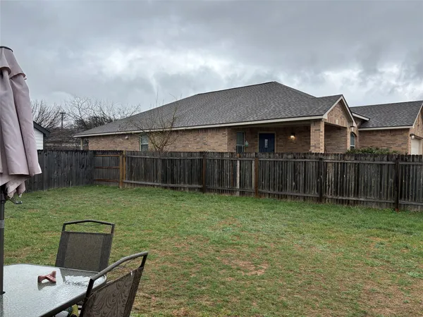 a backyard of a house with wooden floor and fence