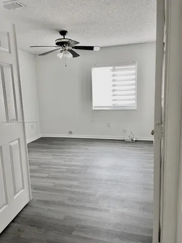 a view of a room with wooden floor and window