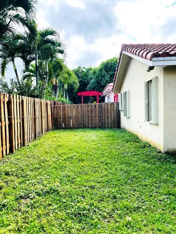 a view of a house with a small yard and wooden fence