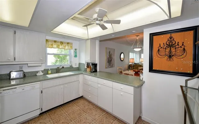 a living room with furniture a large window and stainless steel appliances