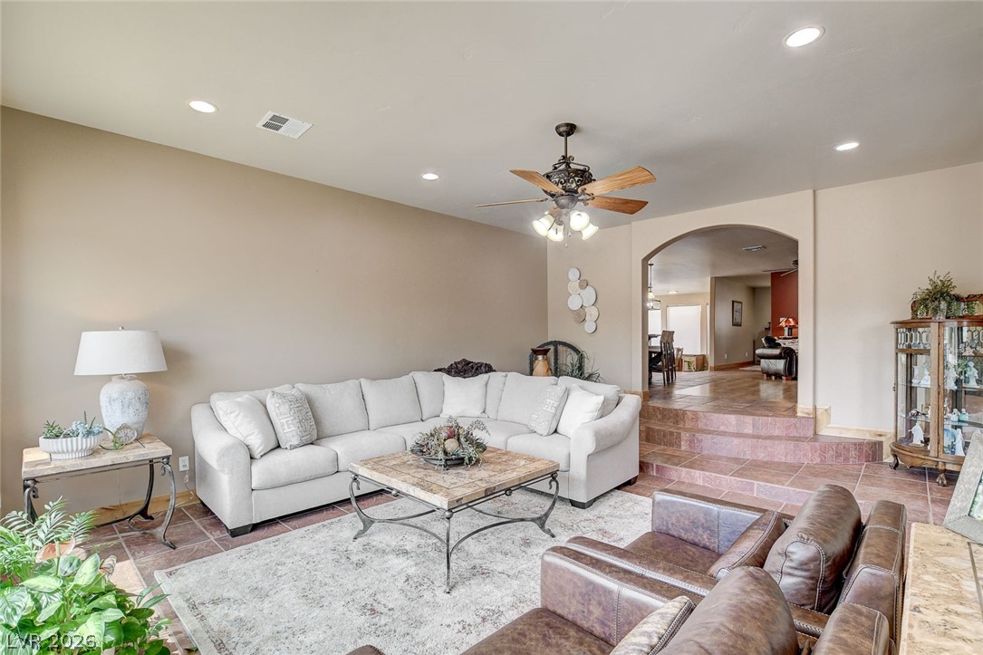 1950 Bowman Road Logandale, NV 89021 - Photo 8 of 81 Recessed lighting and a classic ceiling fan illuminate this living space, connecting seamlessly to a raised dining area.