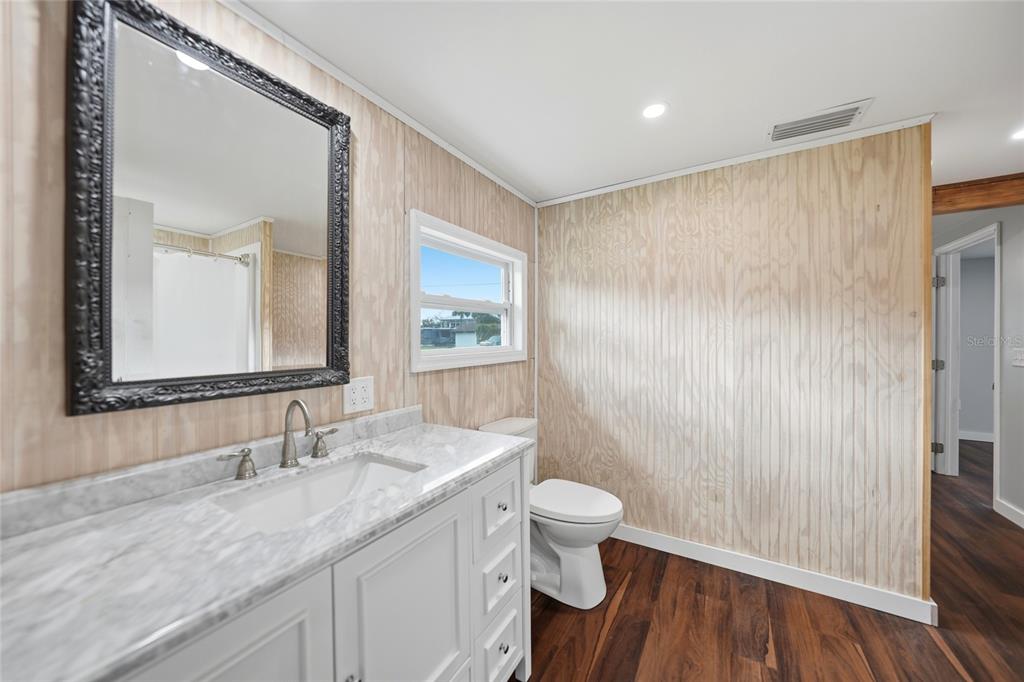 8164 Archie Street Englewood, FL 34224 - Photo 21 of 42 a bathroom with a granite countertop sink a toilet a mirror and vanity