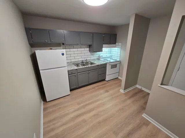 a kitchen with refrigerator and cabinets