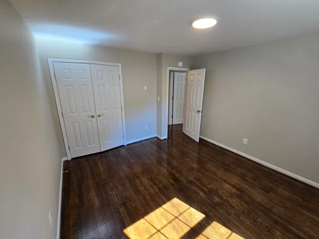 an empty room with wooden floor and cabinet