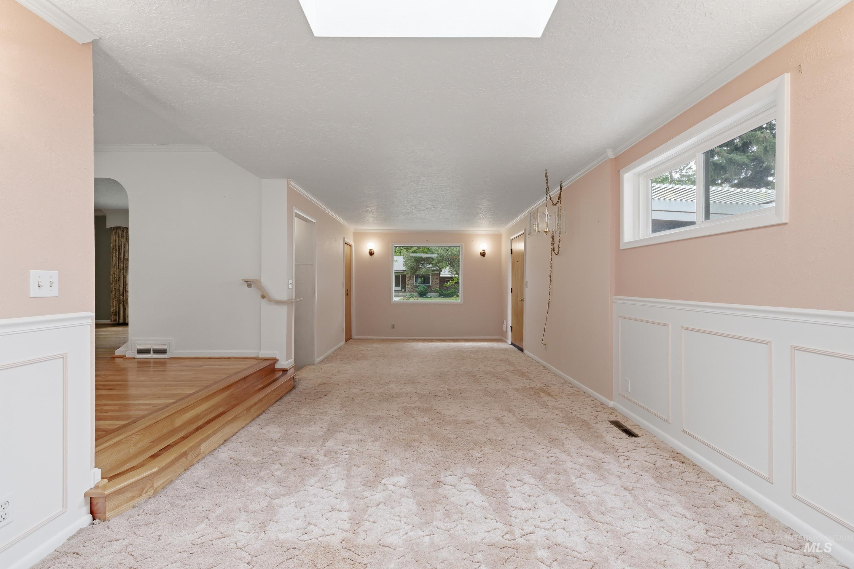 504 West Howe Street Boise, ID 83706 - Photo 11 of 47 Spacious interior room featuring a skylight, light-toned carpeting, and white wainscoting