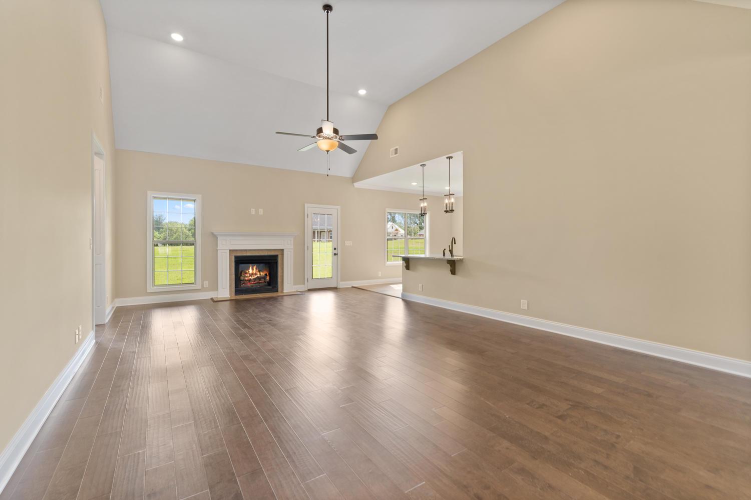 4347 Memory Lane Adams, TN 37010 - Photo 6 of 30 an empty room with wooden floor fireplace and windows