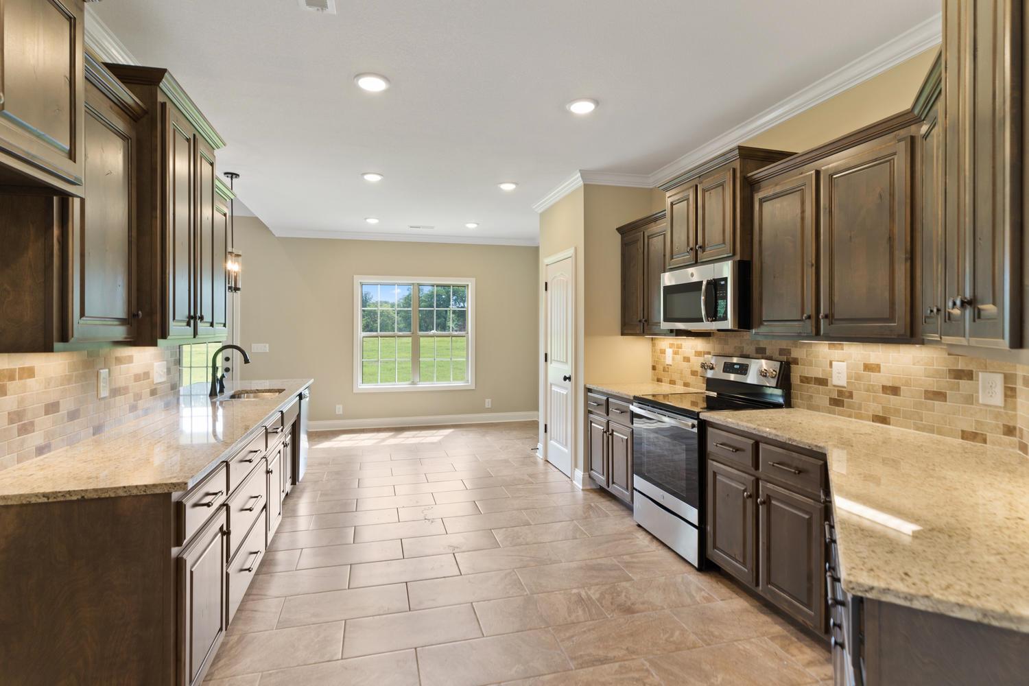 4347 Memory Lane Adams, TN 37010 - Photo 9 of 30 a large kitchen with stainless steel appliances granite countertop a sink stove and cabinets