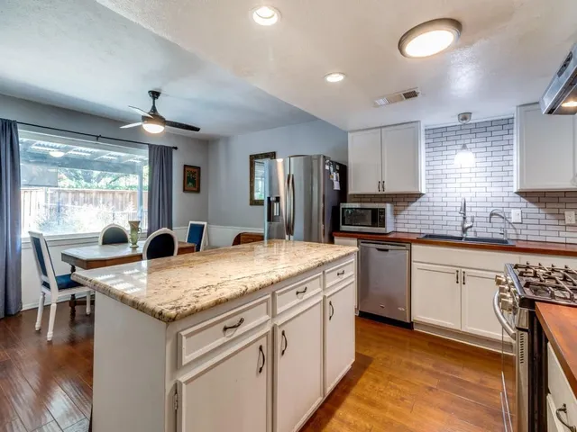 a kitchen with a stove a sink a microwave and cabinets