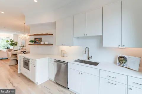 a kitchen with white cabinets and white appliances