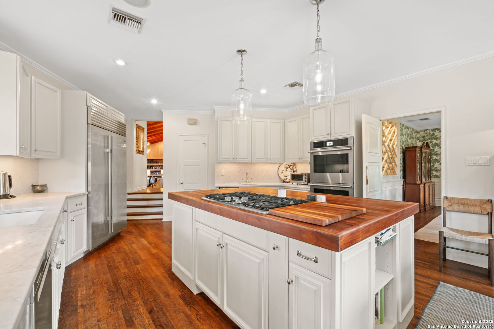 701 Ridgemont Avenue Terrell Hills, TX 78209 - Photo 12 of 48 a kitchen with stainless steel appliances a stove a sink dishwasher a refrigerator white cabinets and wooden floor next to a window