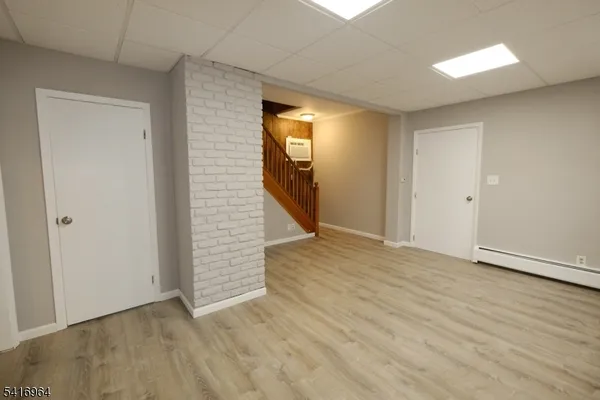 a view of a hallway with wooden floor and closet