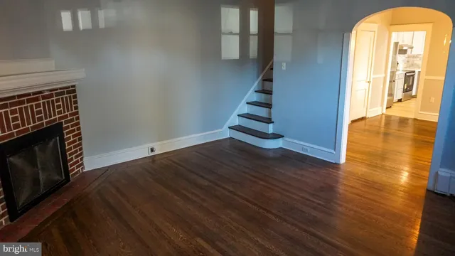 a view of a livingroom with wooden floor and a fireplace