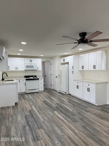 a living room with stainless steel appliances kitchen island granite countertop a sink and cabinets