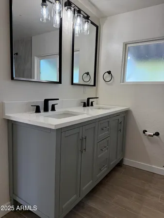 a bathroom with a double vanity sink and mirror