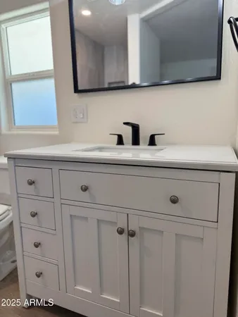 a close view of a sink a mirror and cabinets in a room