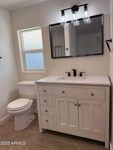 a bathroom with a toilet sink and mirror