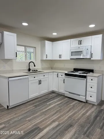 a kitchen with white cabinets stainless steel appliances and sink