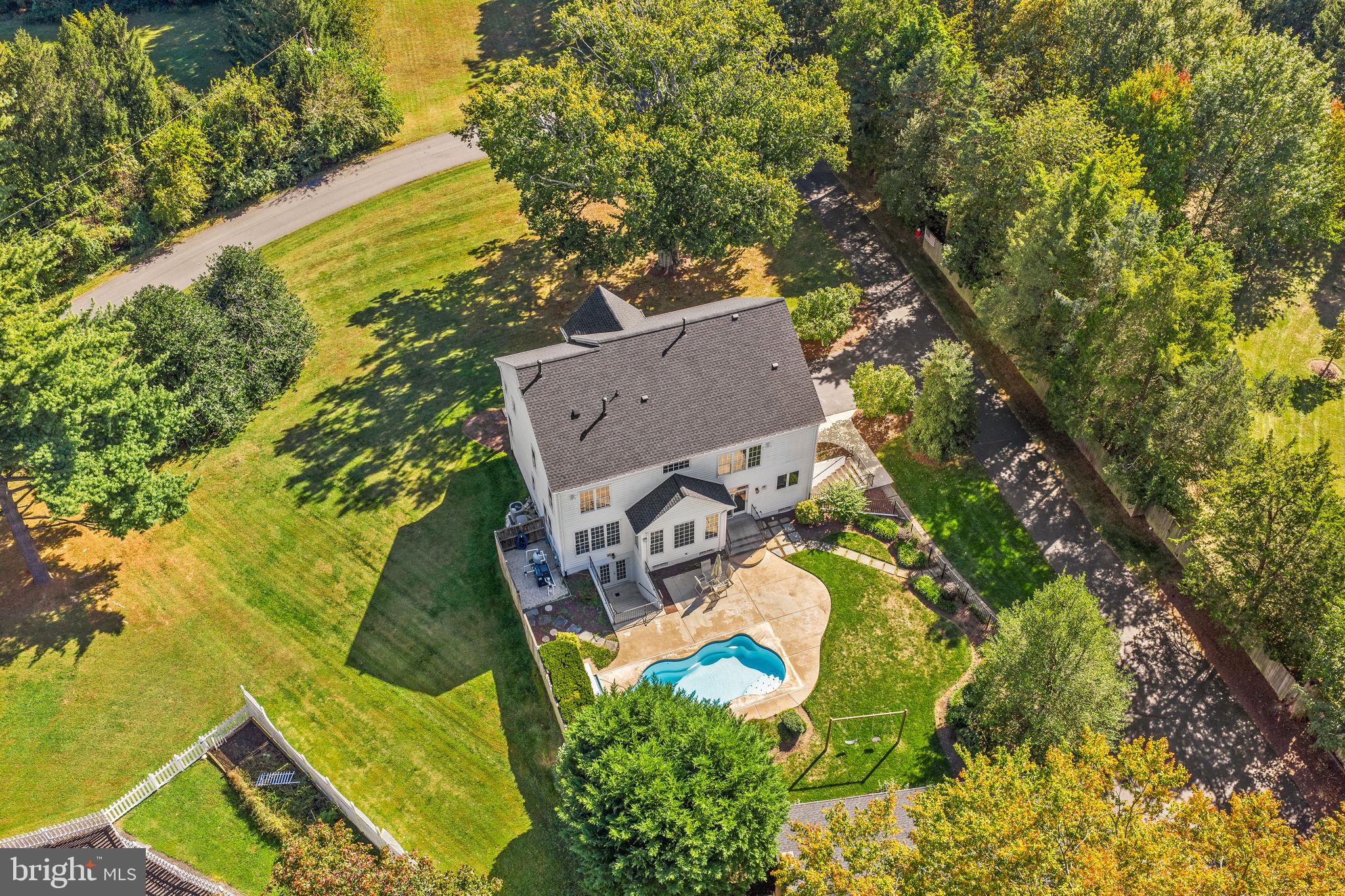 an aerial view of a house with swimming pool and garden space
