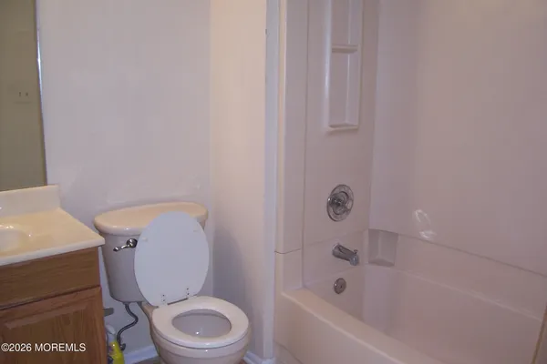 a white toilet sitting next to a bath tub
