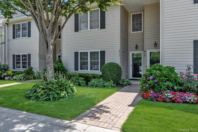 a view of a house with a yard and potted plants
