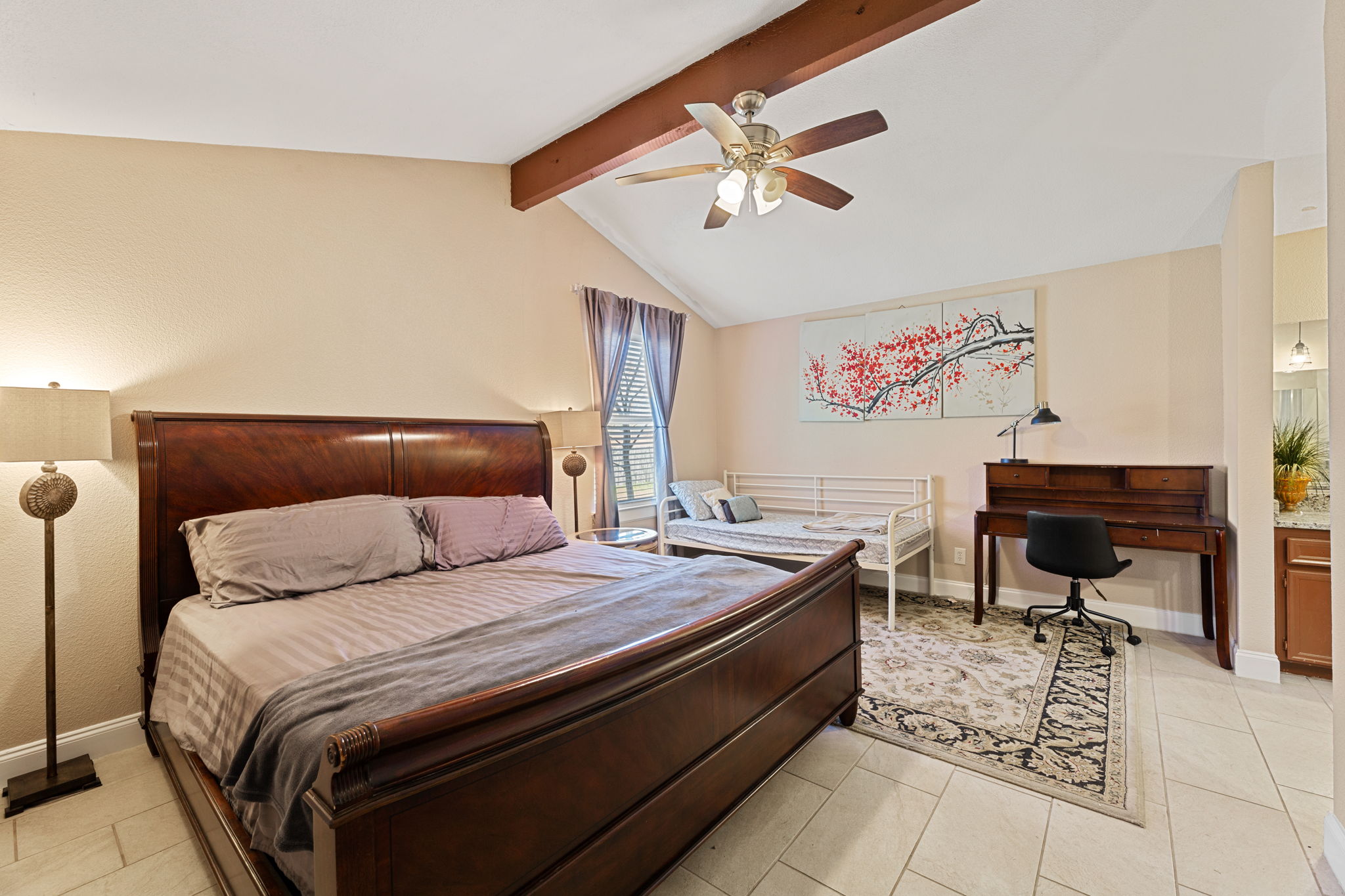 1602 Plateau Ridge Cedar Park, TX 78613 - Photo 18 of 29 Bedroom featuring beamed ceiling, a ceiling fan, connected bathroom, and light tile patterned floors