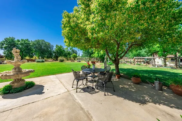 a patio with a table and chairs and potted plants
