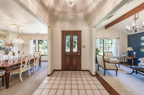 a living room with furniture a dining table and large window with wooden floor
