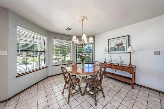 a dining room with furniture a chandelier and window