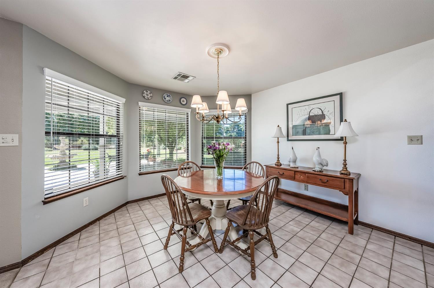 9415 21st Avenue Lemoore, CA 93245 - Photo 25 of 36 a dining room with furniture a chandelier and window