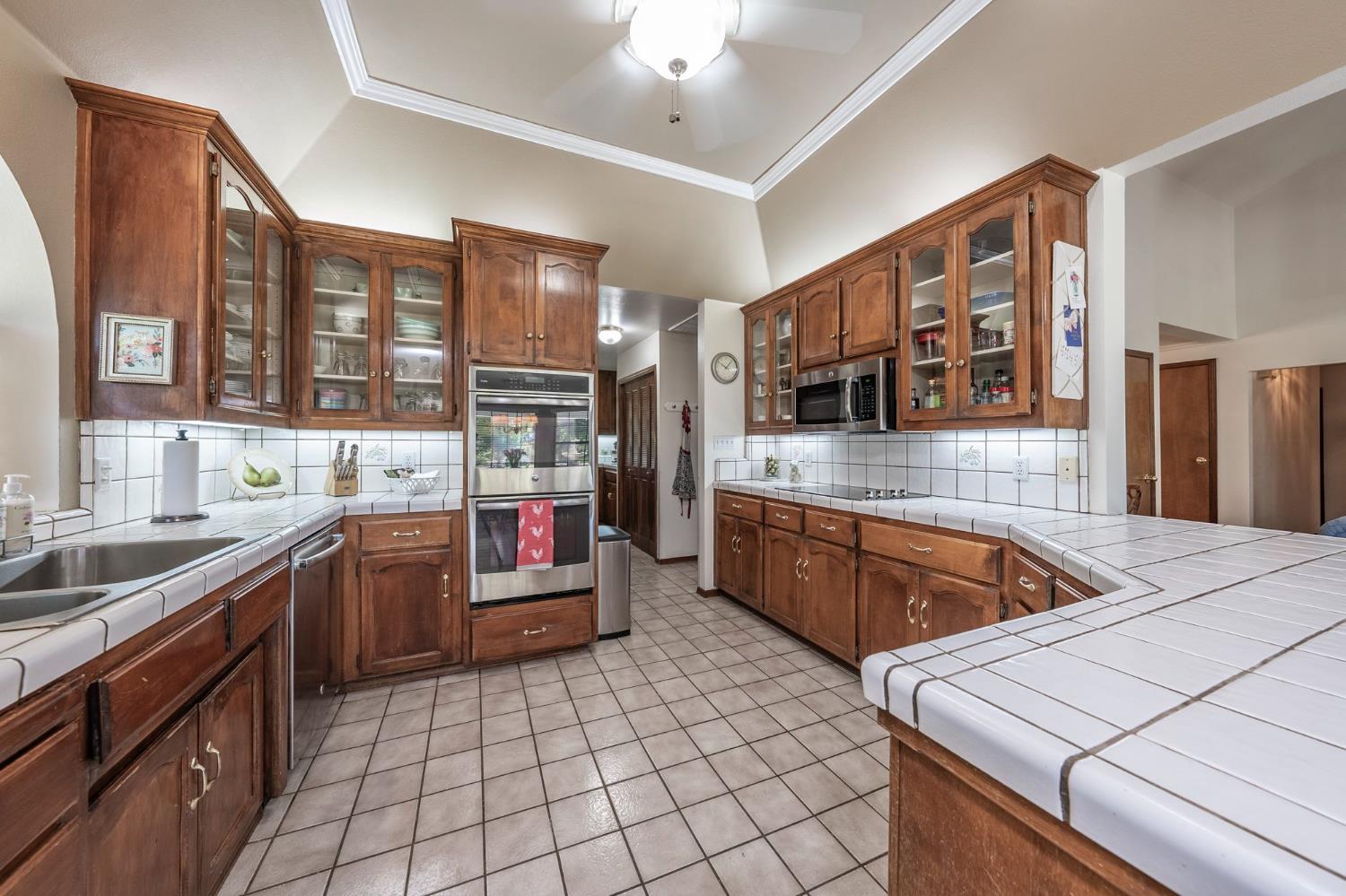 9415 21st Avenue Lemoore, CA 93245 - Photo 27 of 36 a kitchen with stainless steel appliances granite countertop a sink and cabinets