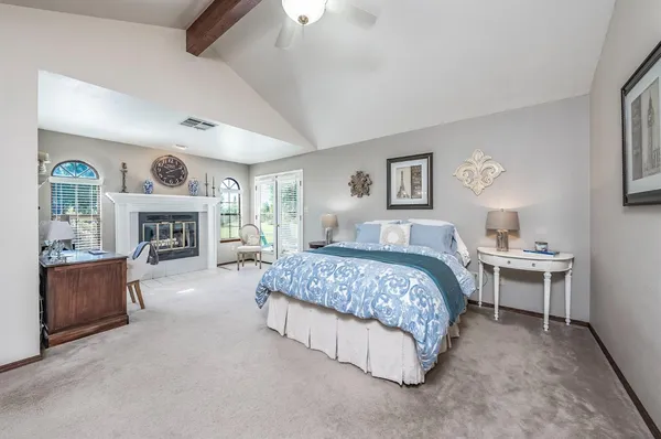 a spacious bedroom with a bed and a fireplace