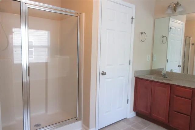 a bathroom with a granite countertop sink mirror and shower