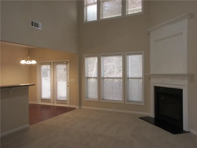 a view of an empty room with a fireplace and a window