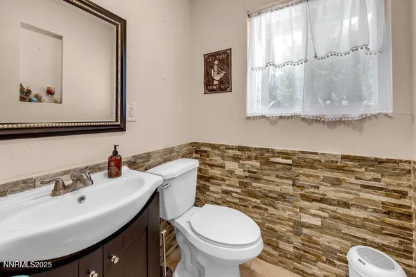 a bathroom with a sink mirror and toilet
