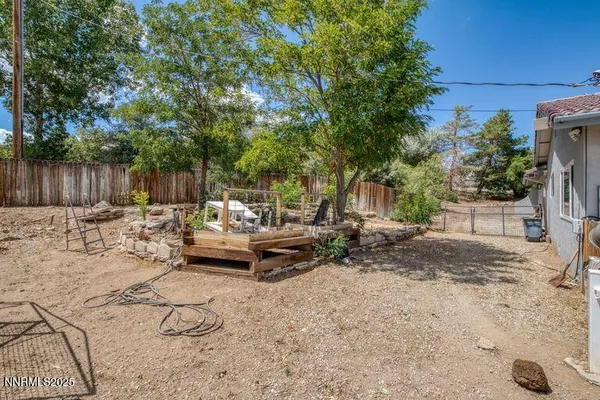 a view of a patio with table and chairs with wooden fence and plants