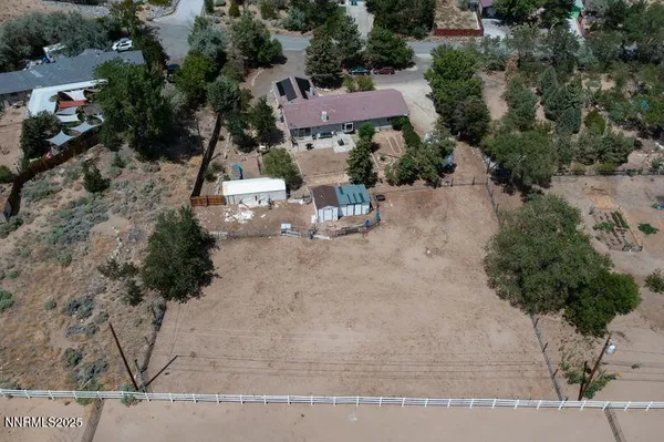 an aerial view of a house with a yard and couple of trees