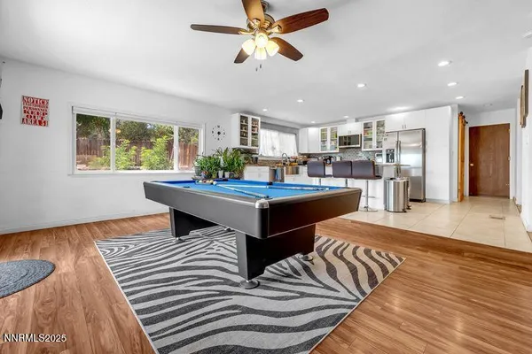 a living room with stainless steel appliances kitchen island furniture and a large window