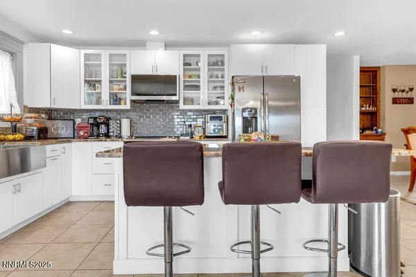 a kitchen with stainless steel appliances granite countertop a refrigerator and a stove top oven