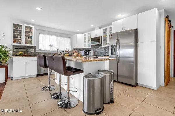a kitchen with stainless steel appliances granite countertop a refrigerator and a stove top oven