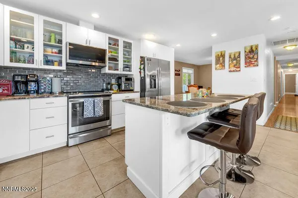 a kitchen with stainless steel appliances granite countertop a stove top oven a sink a counter space and cabinets