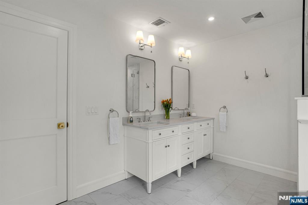331 Wastena Terrace Ridgewood, NJ 07450 - Photo 29 of 49 a bathroom with double vanity sink and mirror