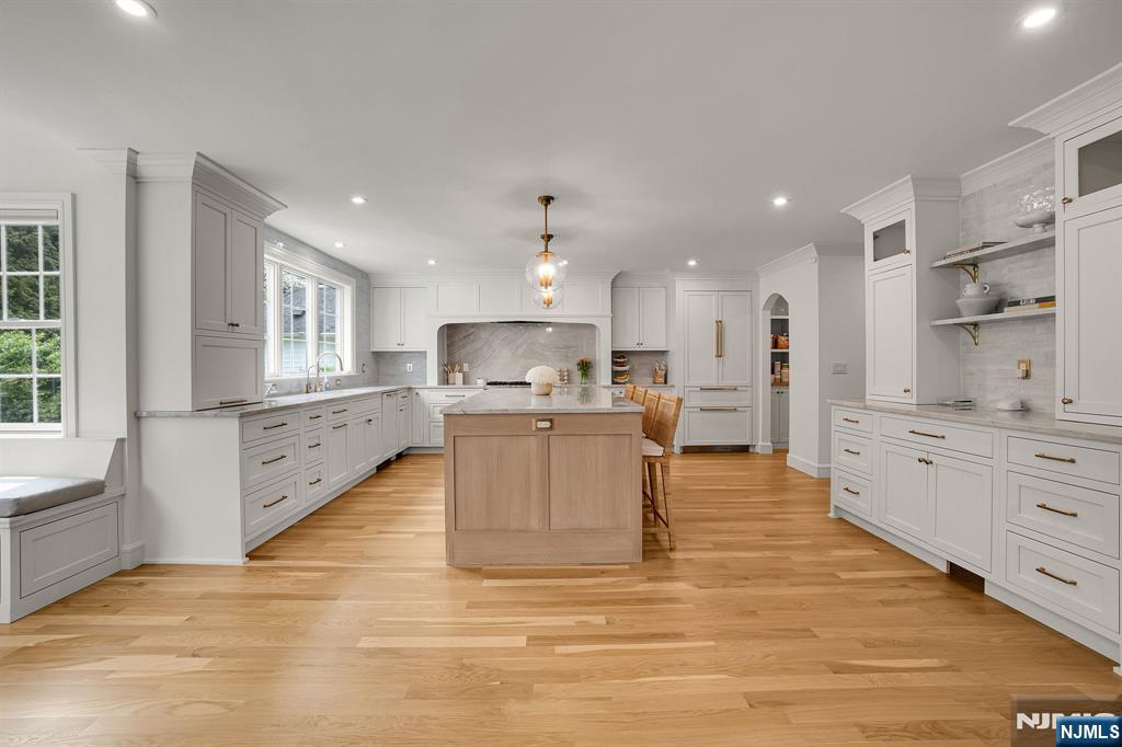 331 Wastena Terrace Ridgewood, NJ 07450 - Photo 4 of 49 a large white kitchen with kitchen island white cabinets and stainless steel appliances
