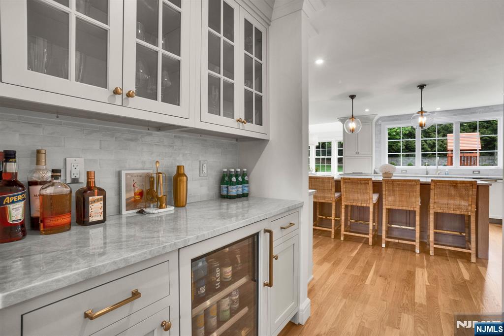 331 Wastena Terrace Ridgewood, NJ 07450 - Photo 10 of 49 an outdoor kitchen with granite countertop a stove a sink a dining table and chairs