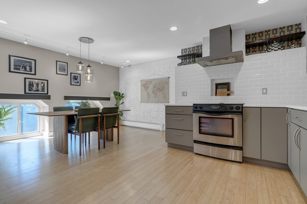 9 Appleton Street, Unit M1 Boston, MA 02116 - Photo 9 of 24 a kitchen with stainless steel appliances kitchen island wooden floor and white cabinets