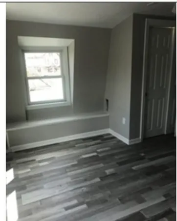 a room with a window and a wooden floor