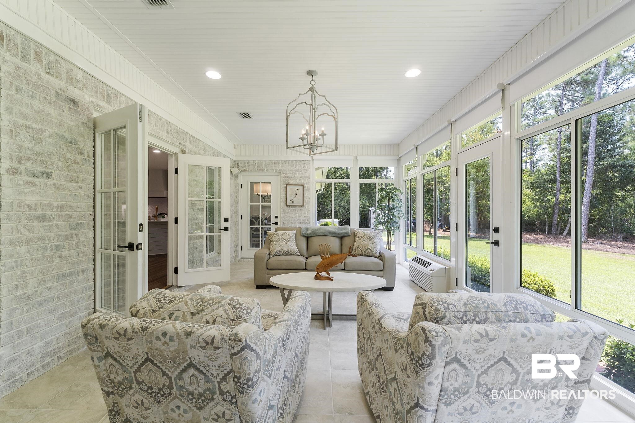 4451 Millhouse Road Gulf Shores, AL 36542 - Photo 12 of 50 Sunroom with a healthy amount of sunlight and a notable chandelier