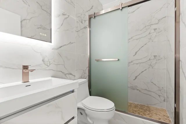 a bathroom with a sink a toilet and shower