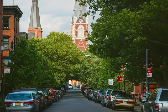a view of a city street with a cars parked on the road